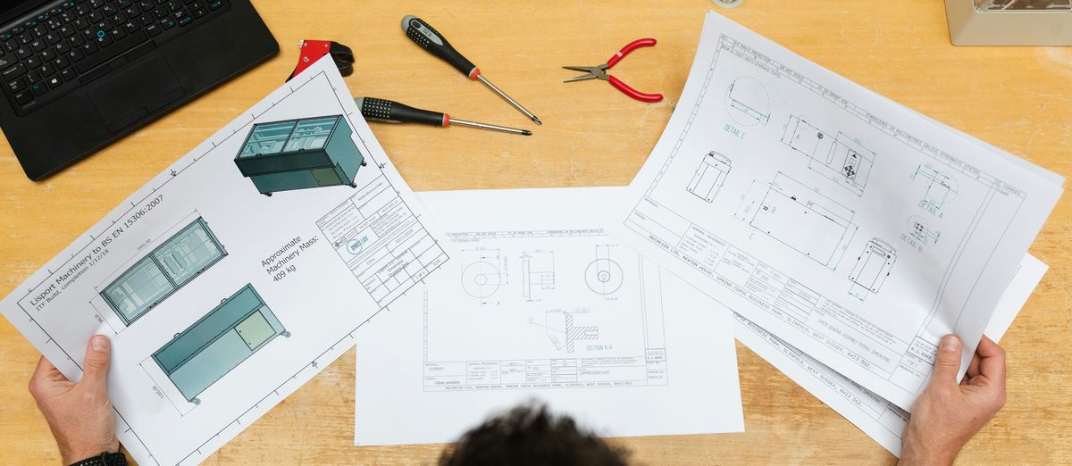 Technical drawings spread across a desk
